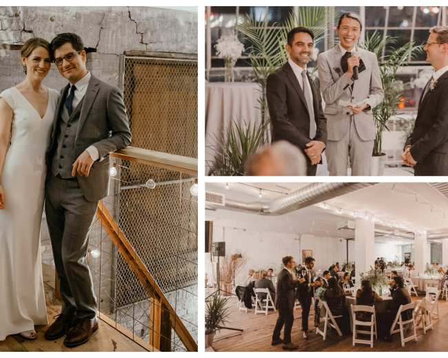 A couple stands together in formal attire on a wooden balcony while guests gather at tables below in a well-lit venue adorned with greenery for a wedding celebration.