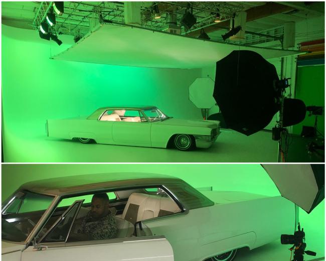 A vintage white car is positioned in a green studio with lighting equipment set up for photography.