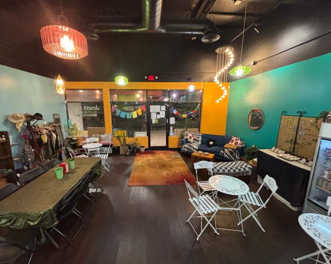 The image shows a colorful indoor space furnished with chairs, tables, and decorative elements, featuring a bright blue and orange color scheme.