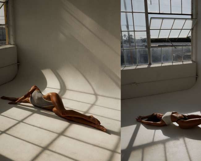 The image features a figure in a swimsuit gracefully stretching across a minimalist, sunlit space with large windows, casting elongated shadows on the floor.