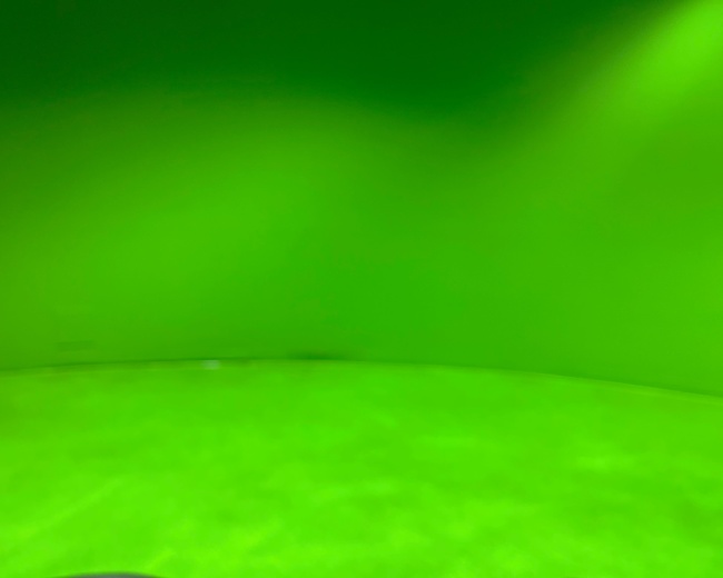 A bright green backdrop in a curved setting.