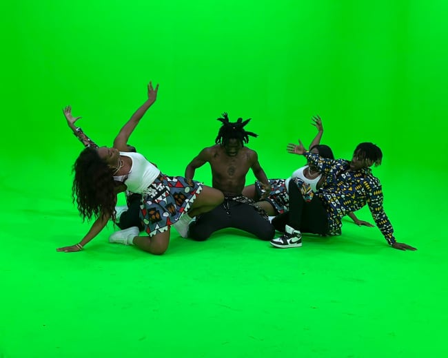 A group of five individuals poses dynamically on a green screen backdrop.
