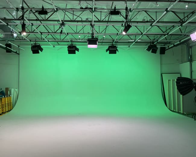 A green screen studio with bright lighting and a smooth background.