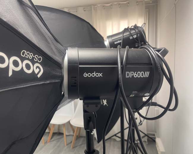 The image shows a close-up of two Godox studio lights equipped with softboxes, positioned in a photography studio setting.