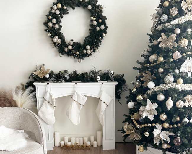 The image features a decorated living room with a Christmas tree adorned with ornaments, a white mantle with stockings, and a wreath on the wall.