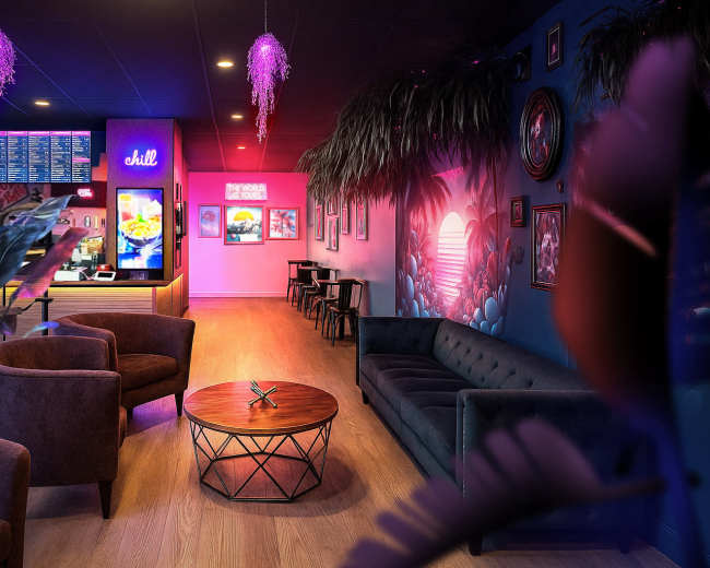 The image shows a stylish lounge area featuring comfortable seating, a circular coffee table, and a colorful wall mural with neon lighting.