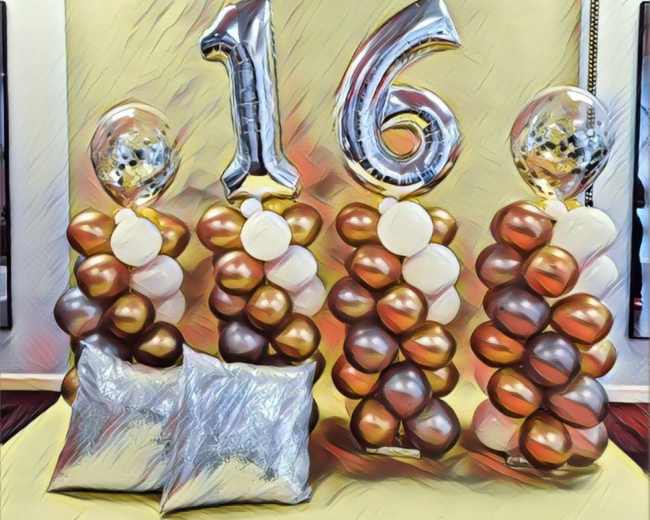 Decorative balloon columns in gold and brown hues, topped with clear balloons, alongside a large "16" silver foil balloon against a yellow backdrop.