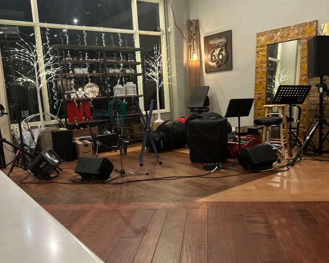 A performance space with musical instruments, microphones, and decor, including lights and a large mirror.