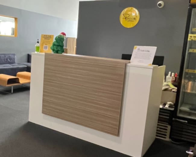 A reception area with a countertop, seating against the wall, and a beverage refrigerator in the corner.