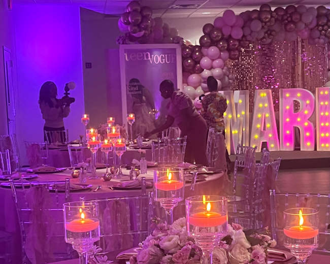 A decorated banquet hall features tables set with candles and floral arrangements, while large illuminated letters spell "MARRIED" in the background.