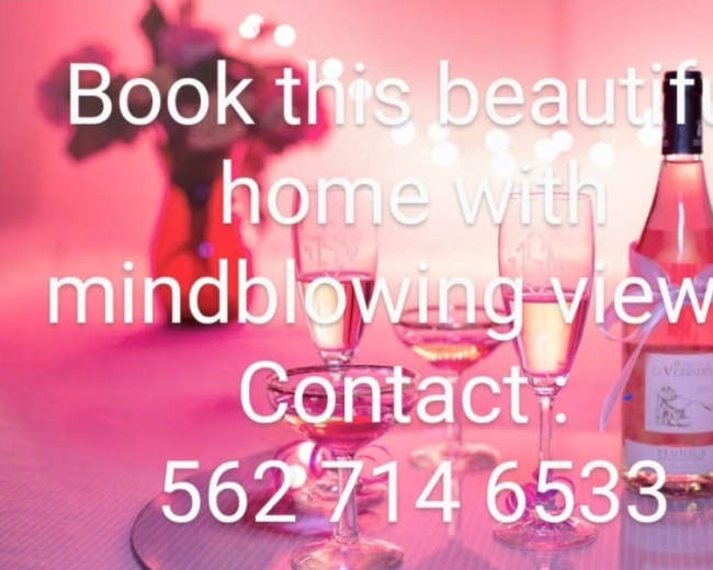Three glasses of rosé wine in front of a softly lit pink background, advertising a home with views for booking.