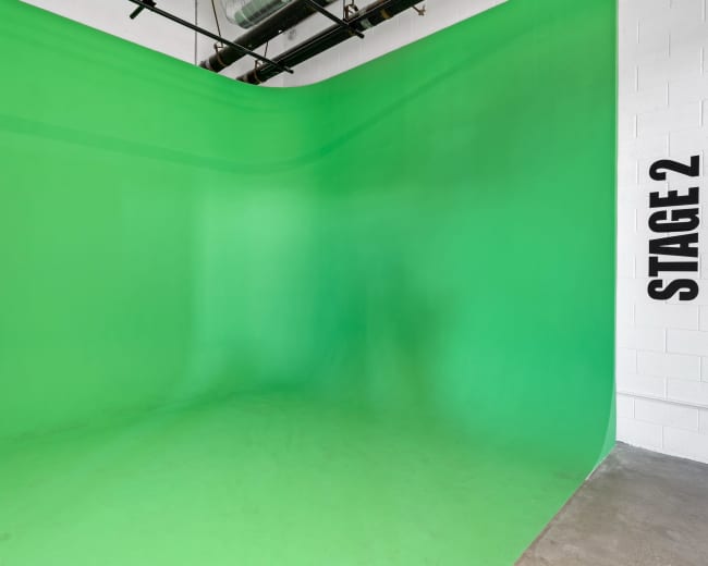 A green screen backdrop in a studio space labeled "STAGE 2."