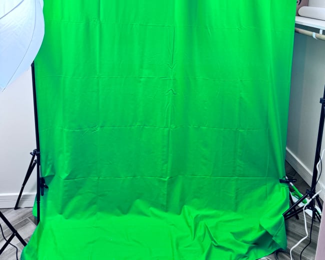 A green backdrop with two softbox lights positioned on either side.