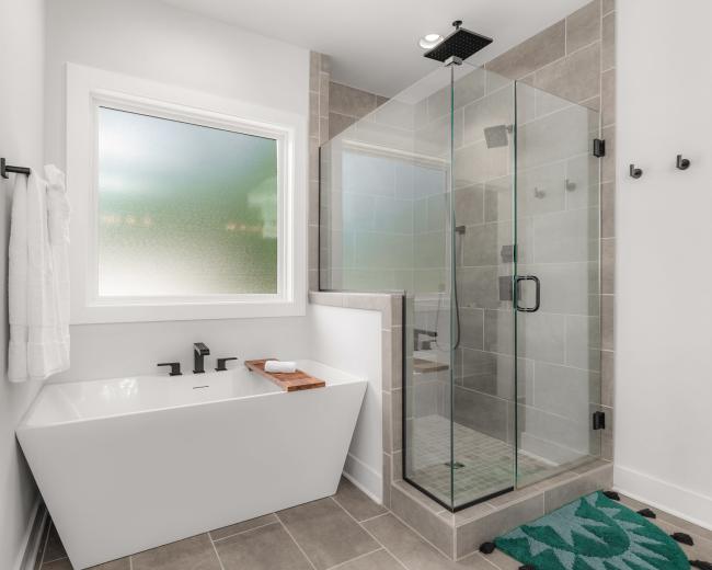 The bathroom features a modern freestanding tub, a glass-enclosed shower, and a window allowing natural light.