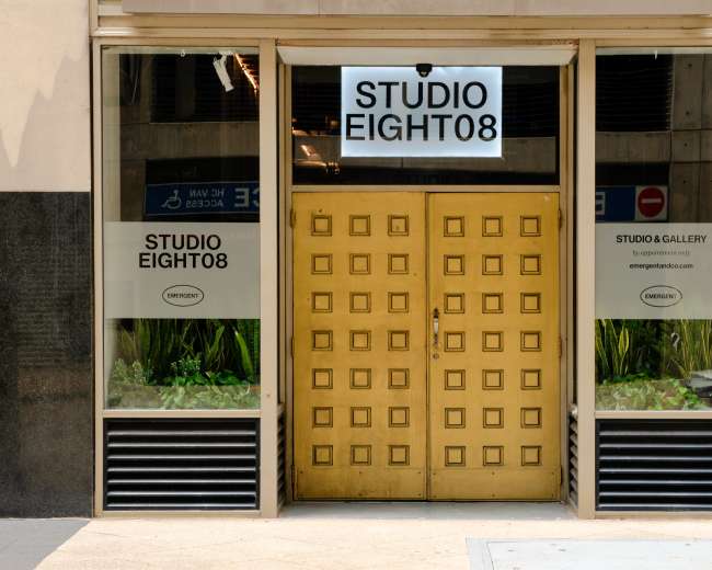 The image shows the entrance of a building with a set of large, golden double doors and windows marked with the name "STUDIO EIGHT08."