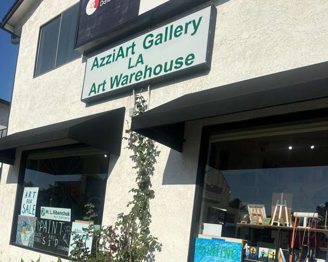 The image shows the exterior of AzziArt Gallery LA Art Warehouse, featuring a sign and colorful storefront windows displaying artwork and advertisements for classes.