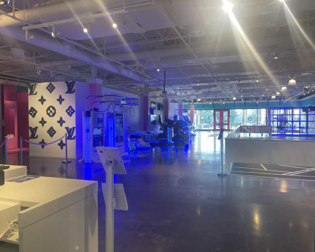 A spacious, brightly lit interior of a modern retail space with workout equipment and colorful wall designs.