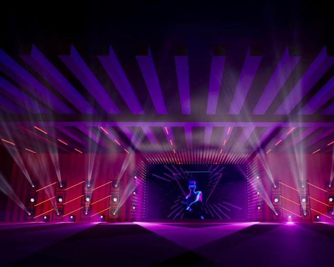 A stage is illuminated with colorful lights and beams, featuring a central backdrop with a visual display and a figure performing.