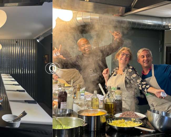 The image shows a well-equipped cooking studio with a clean, organized countertop on one side and a lively group of three people cooking and having fun on the other side.
