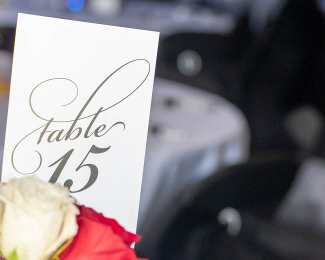 A table setting displays a card labeled "Table 15" alongside a bouquet of roses.