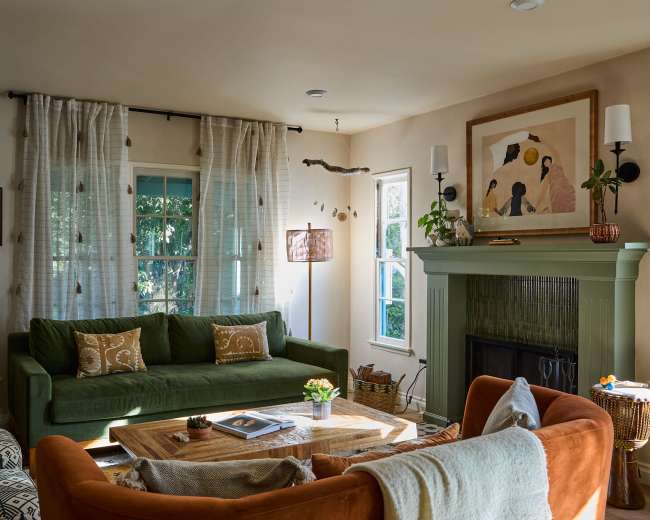 The living room features a green couch, an orange armchair, a wooden coffee table, and large windows with sheer curtains.