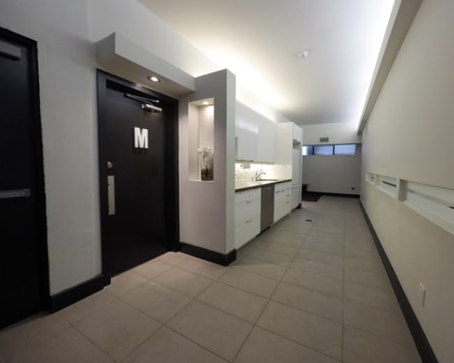 A narrow hallway with a kitchen area on the left and a door labeled "M" on the right.