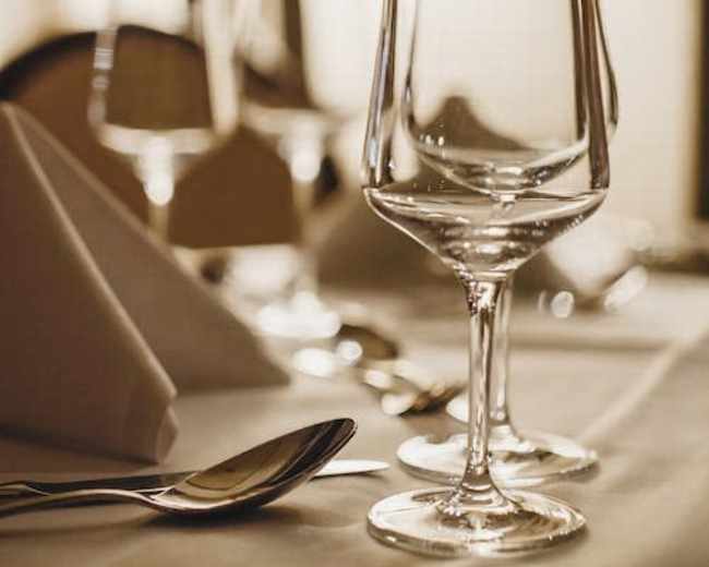 A set table with elegant glassware, folded napkins, and cutlery arranged neatly.