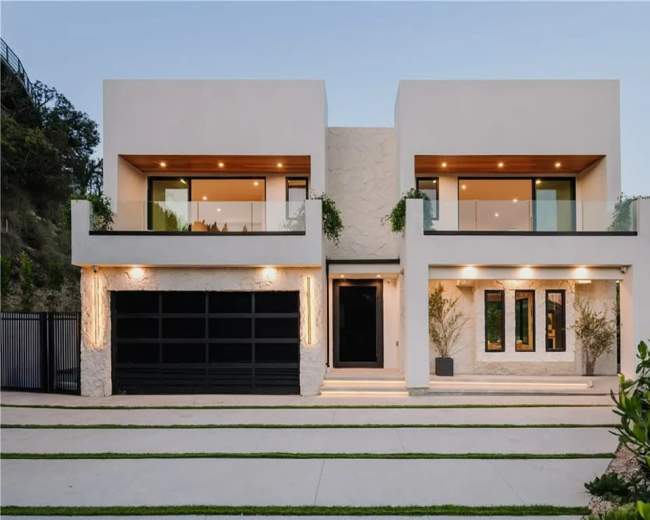 The image shows a modern two-story house with large windows, a black garage door, and a landscaped front yard.