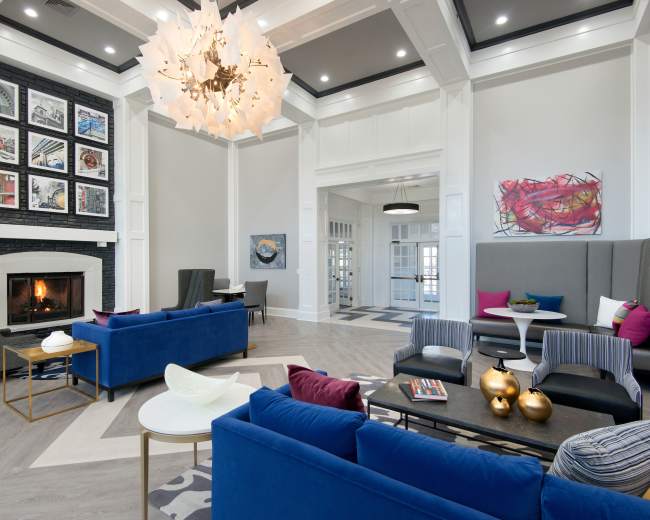 A modern living area featuring a fireplace, contemporary seating arrangements, and artwork on the walls.