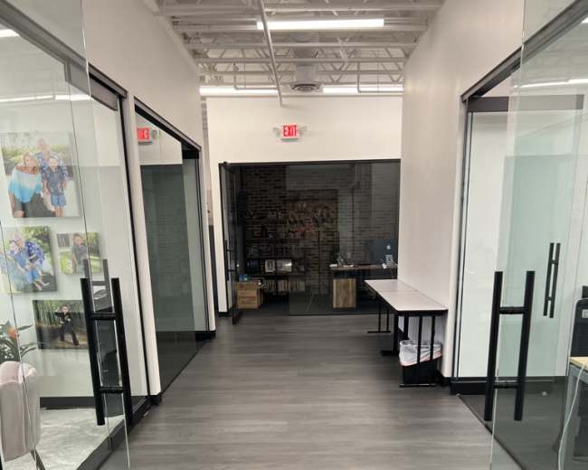 A long corridor with glass doors on either side leading to offices, and tables set up along the walls.