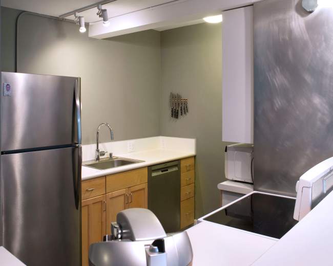 A modern kitchen features stainless steel appliances, wooden cabinets, and a spacious countertop.