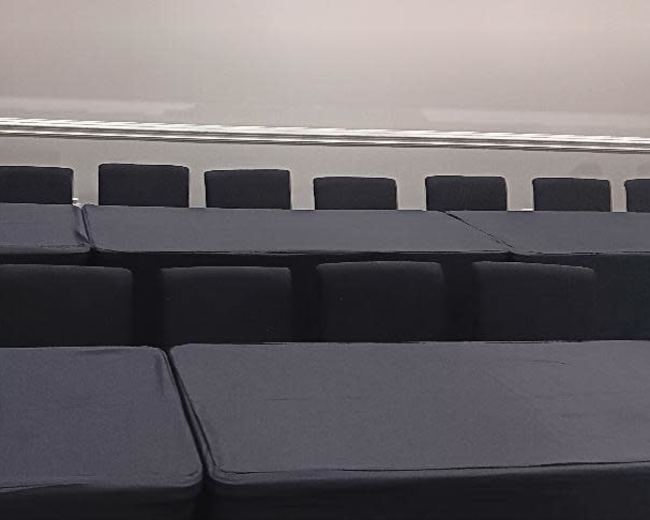 A series of stacked black cushions arranged on a flat surface.