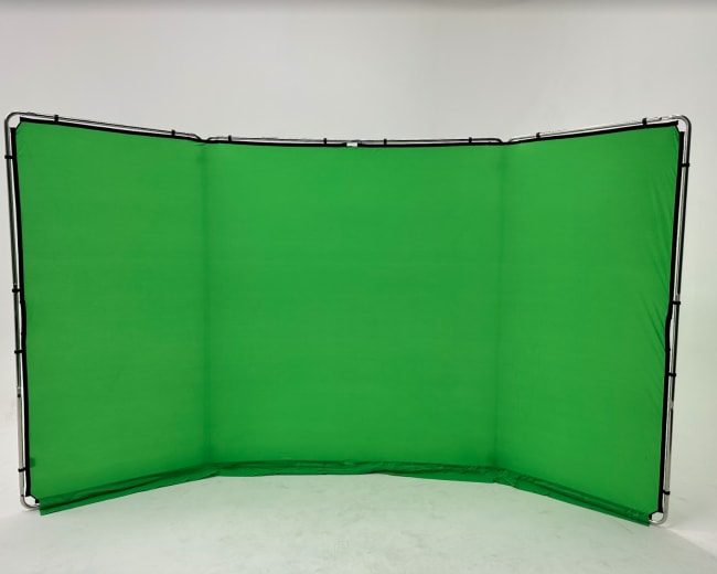 A large green backdrop set up on a white surface, likely for photography or video production.