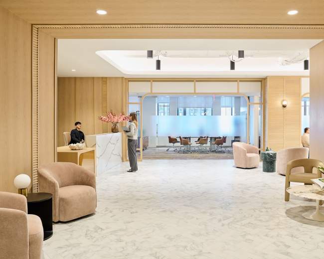 The image depicts a modern reception area with marble flooring, wooden paneling, and seating arrangements, featuring a front desk and a waiting area.