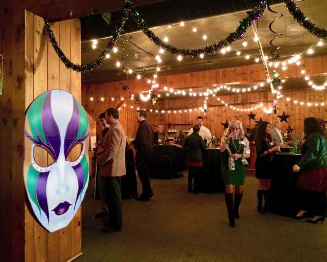 A festive party scene features guests mingling in a decorated room with string lights and a large decorative mask on the wall.