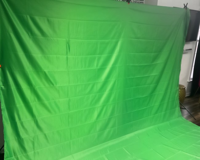 A flat green backdrop used for photography or video production.
