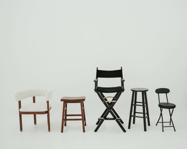 Five different styles of chairs are arranged in a line against a plain white background.