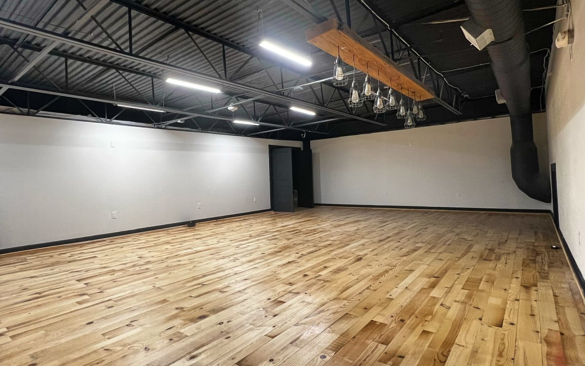 Modern/industrial studio space with wood flooring located near IAH