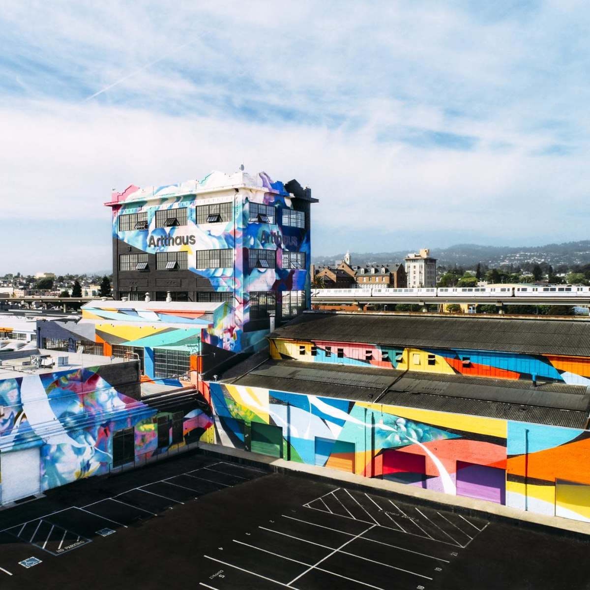 A large building complex with vibrant murals covering its exterior surfaces.