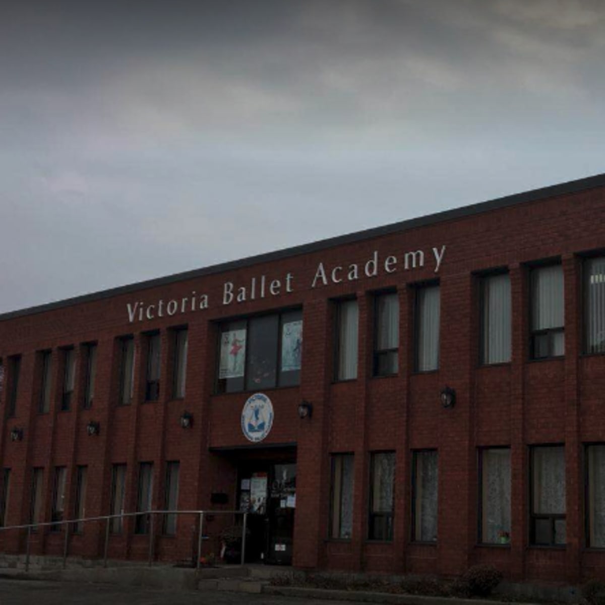 A brick building with large windows, prominently featuring the sign "Victoria Ballet Academy" above the entrance.