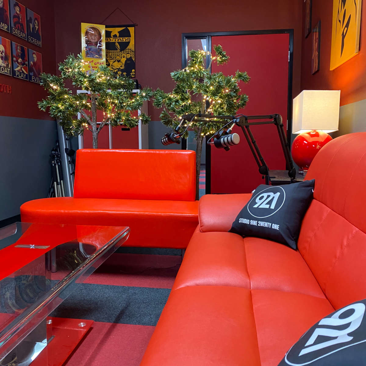 A lounge area with red sofas, decorative trees with lights, and a glass coffee table.