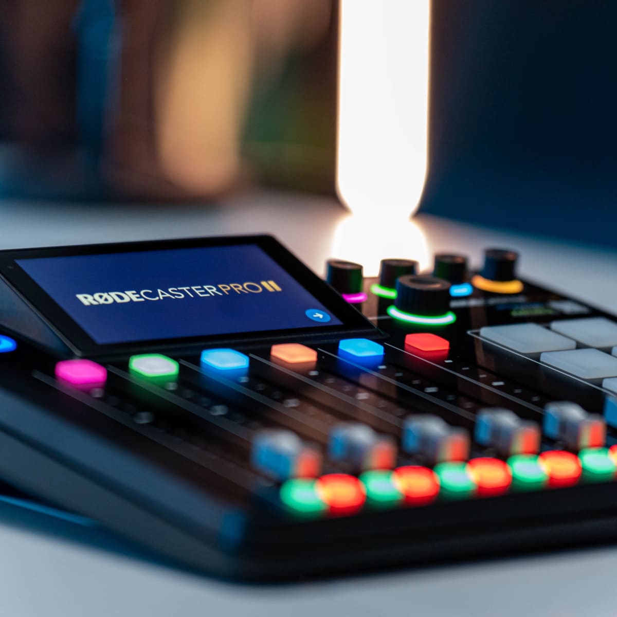A Rodecaster Pro II audio mixing console with colorful buttons and a digital display.