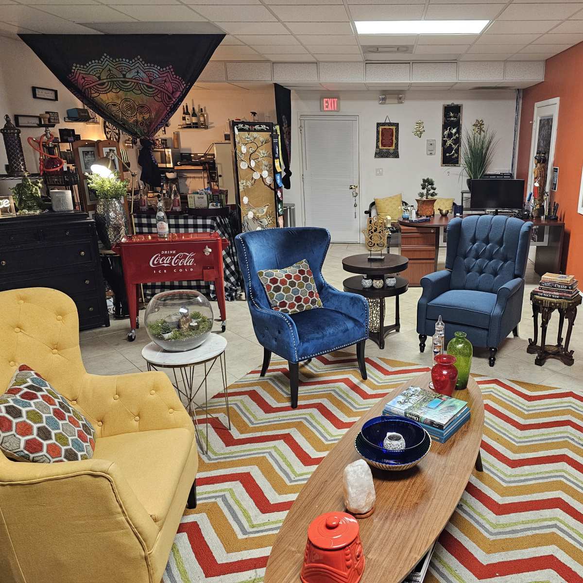 A decorated room with colorful seating arrangements, a patterned rug, and various decorative items on display.