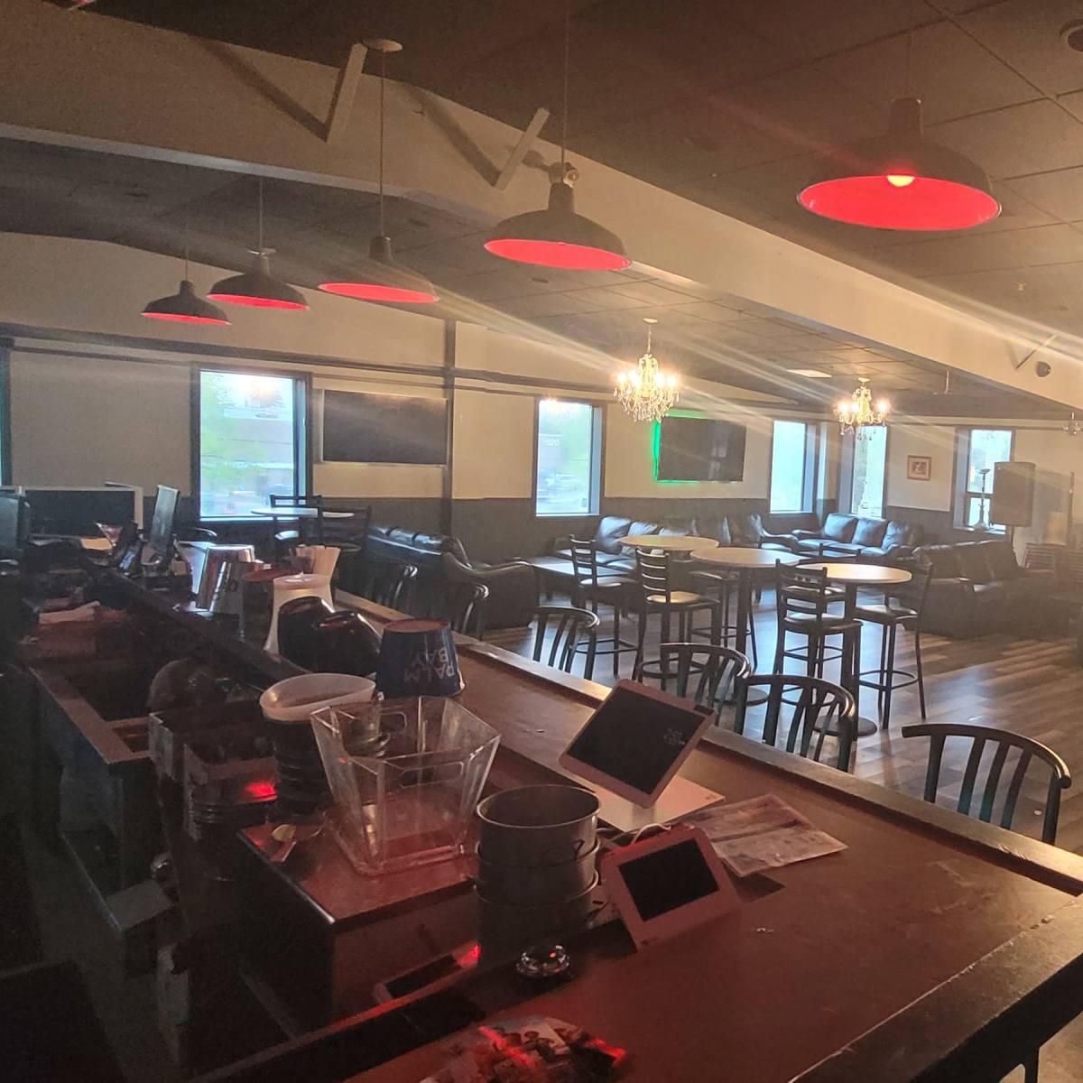 A dimly lit cafe or lounge with leather seating, tabletop games, and a bar area.