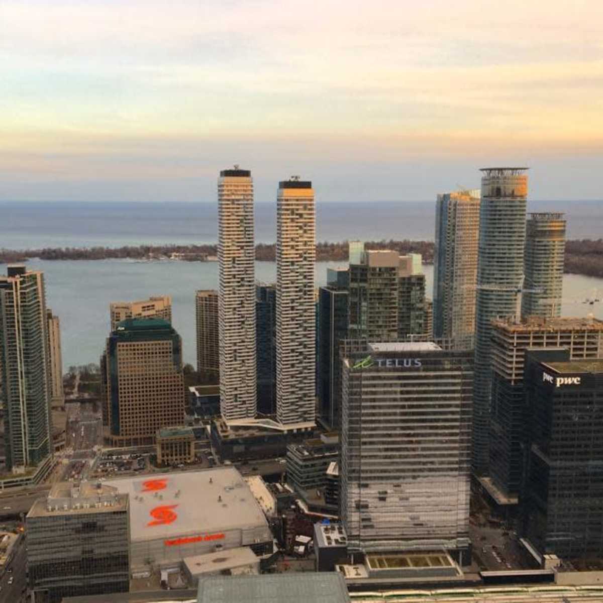 A skyline of tall buildings along a waterfront, with a mix of urban structures and a body of water in the background.