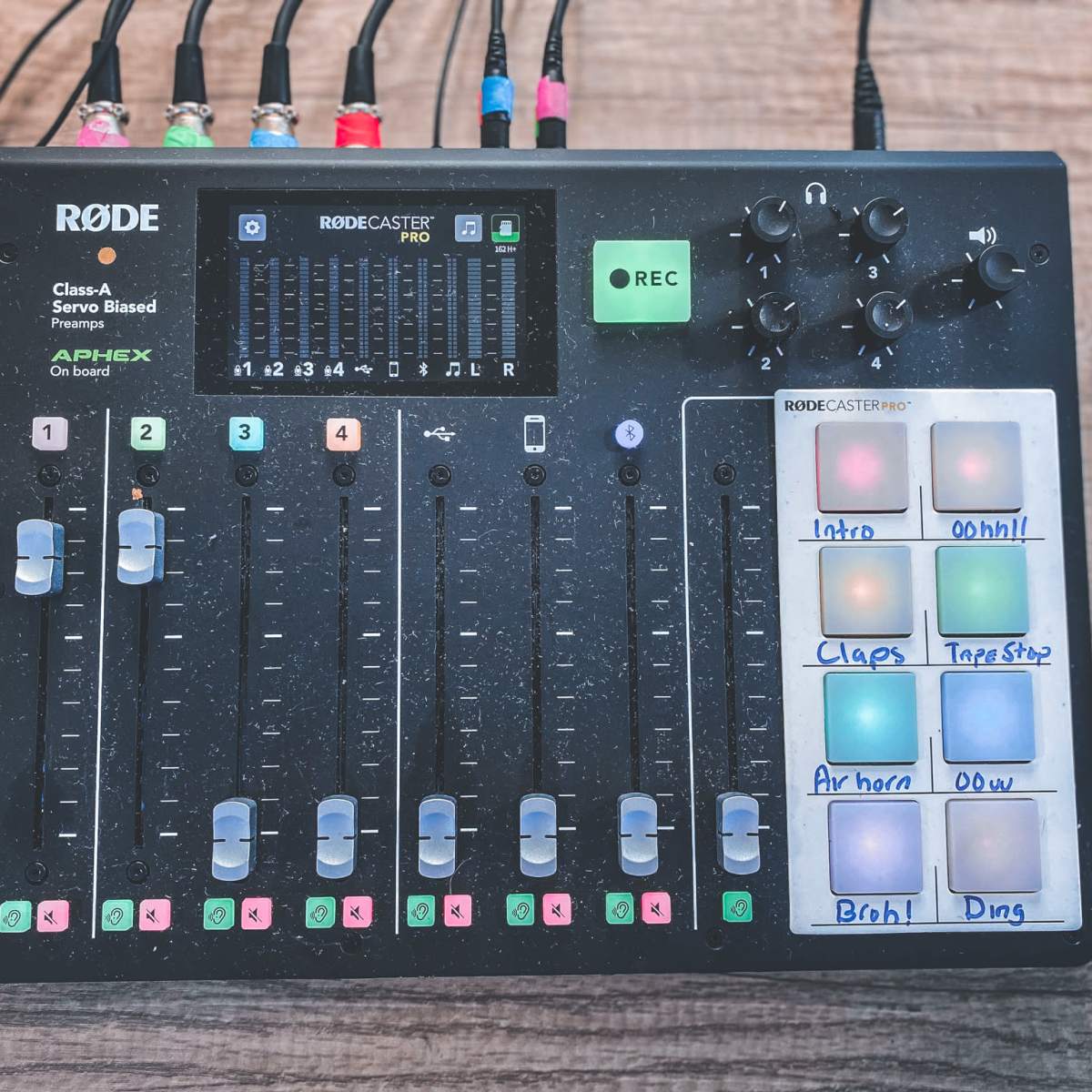 A Rodecaster Pro audio interface with multiple faders, buttons, and recording controls.