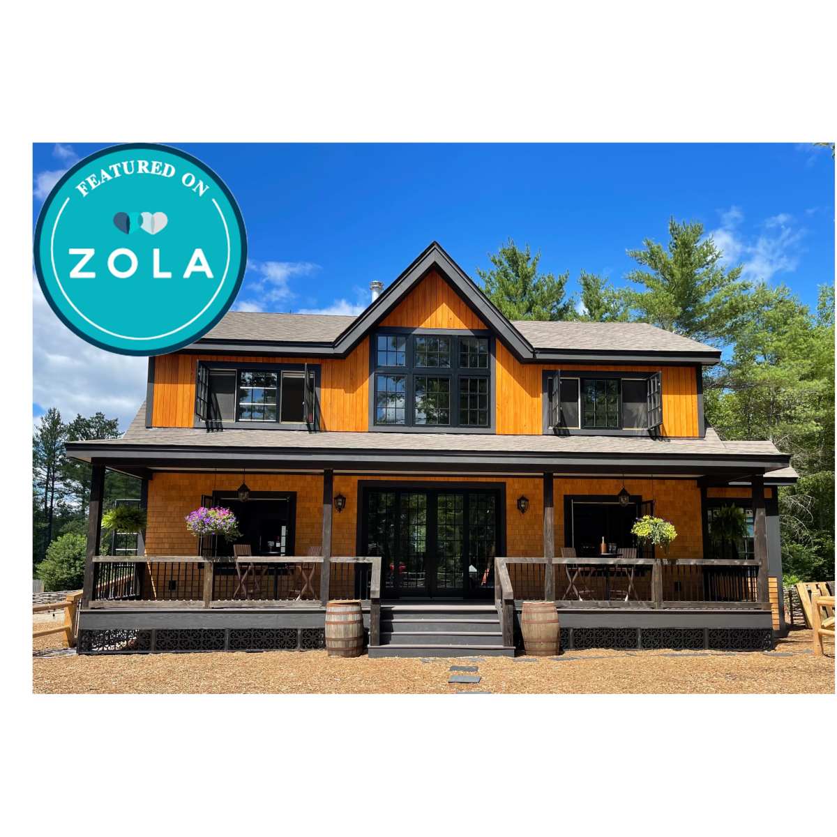 A two-story orange and black house with a front porch, surrounded by trees and featuring flower pots on the railings.