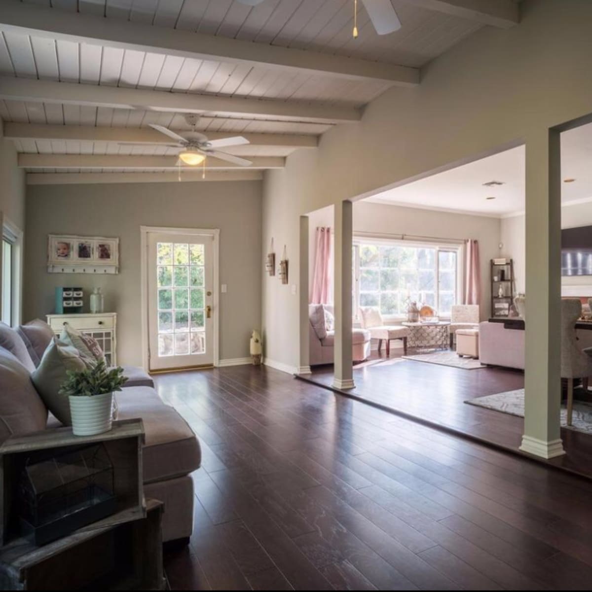An open-concept living area featuring a seating space with a couch on the left and a dining area visible in the background.