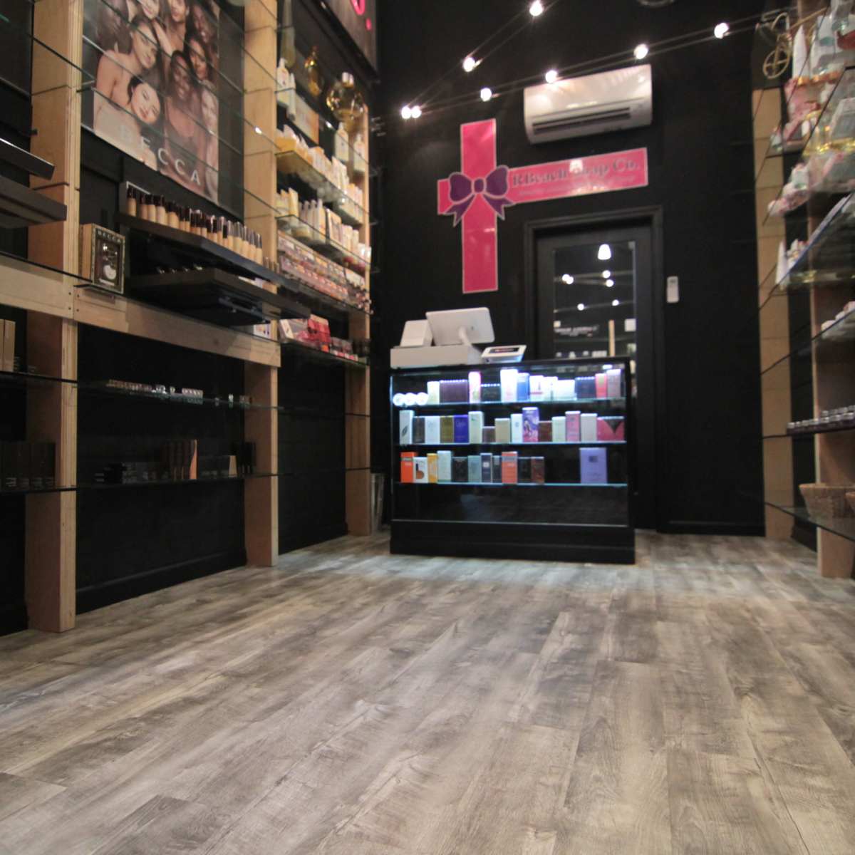 The interior of a retail store displaying various beauty products on shelves and a checkout counter in the background.