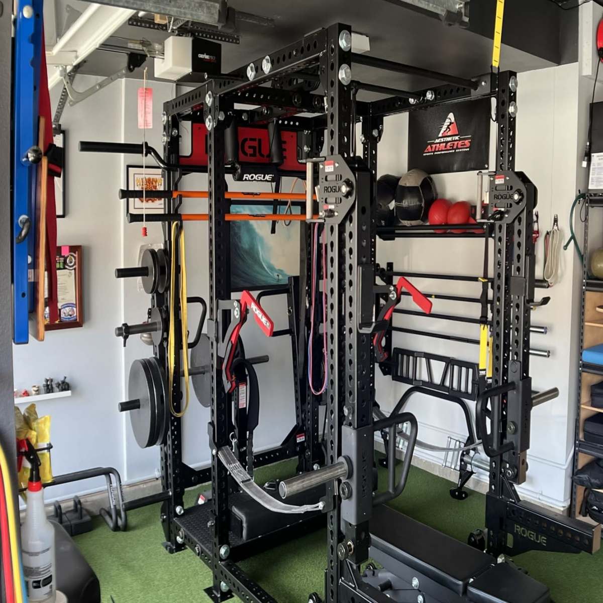 A well-equipped home gym featuring a power rack, various weights, and exercise accessories organized on shelves and walls.